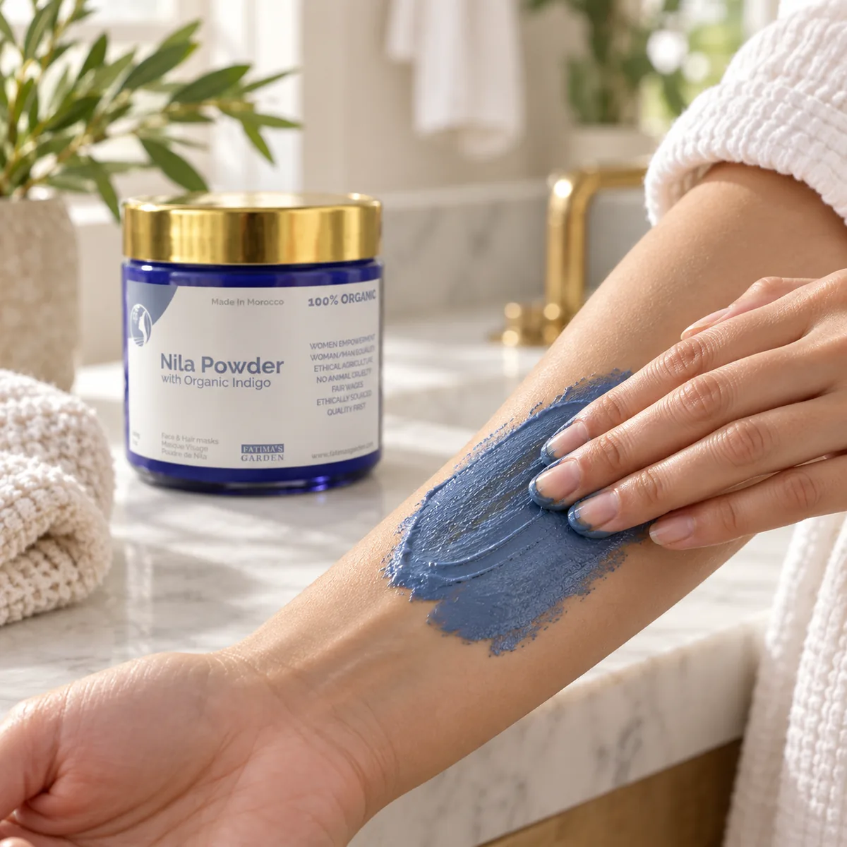 Blue nila paste spread on a forearm in a bathroom, the Fatima’s Garden jar beside it